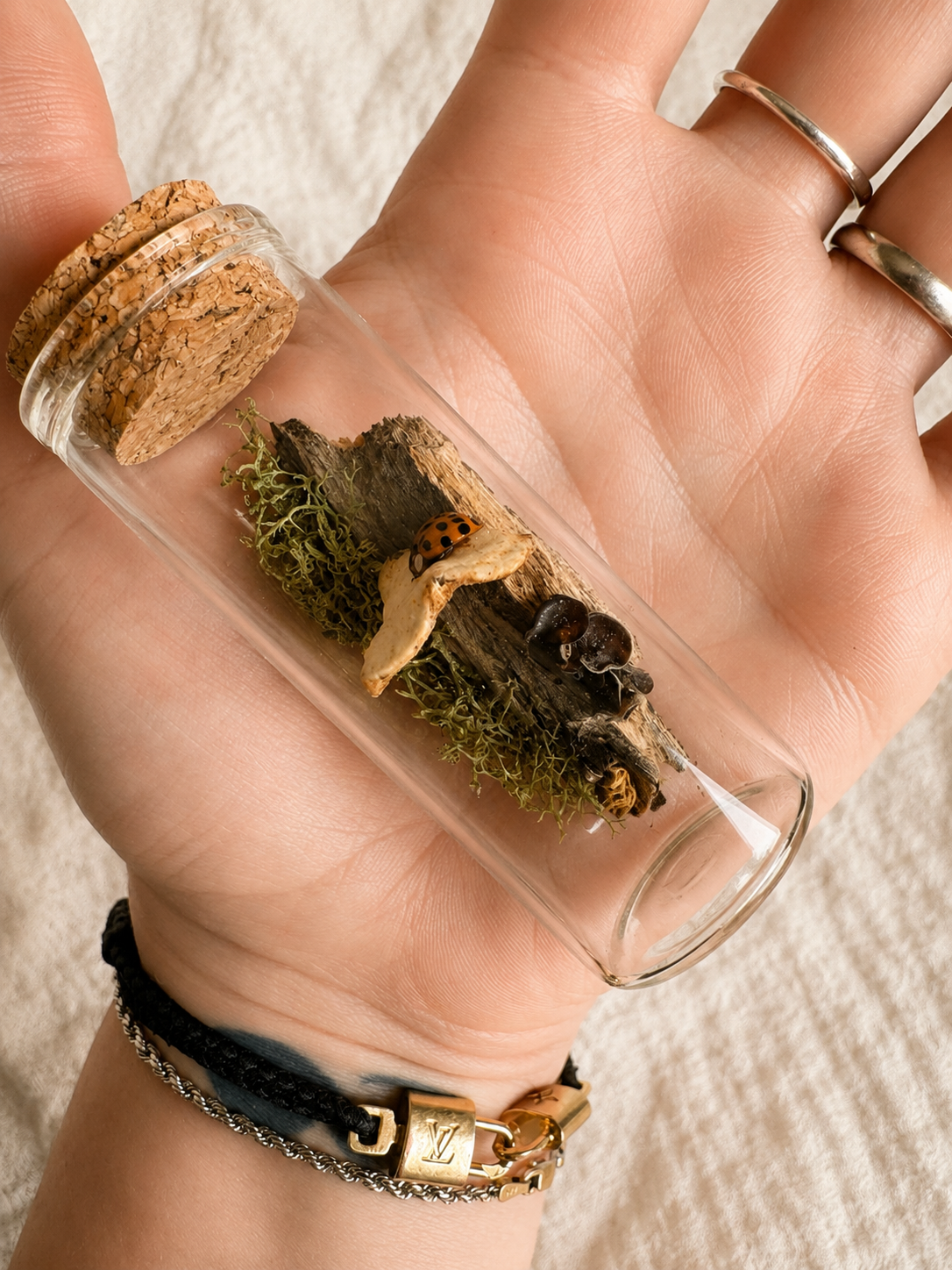 Handmade tiny woodland world glass vial shown in hand for scale